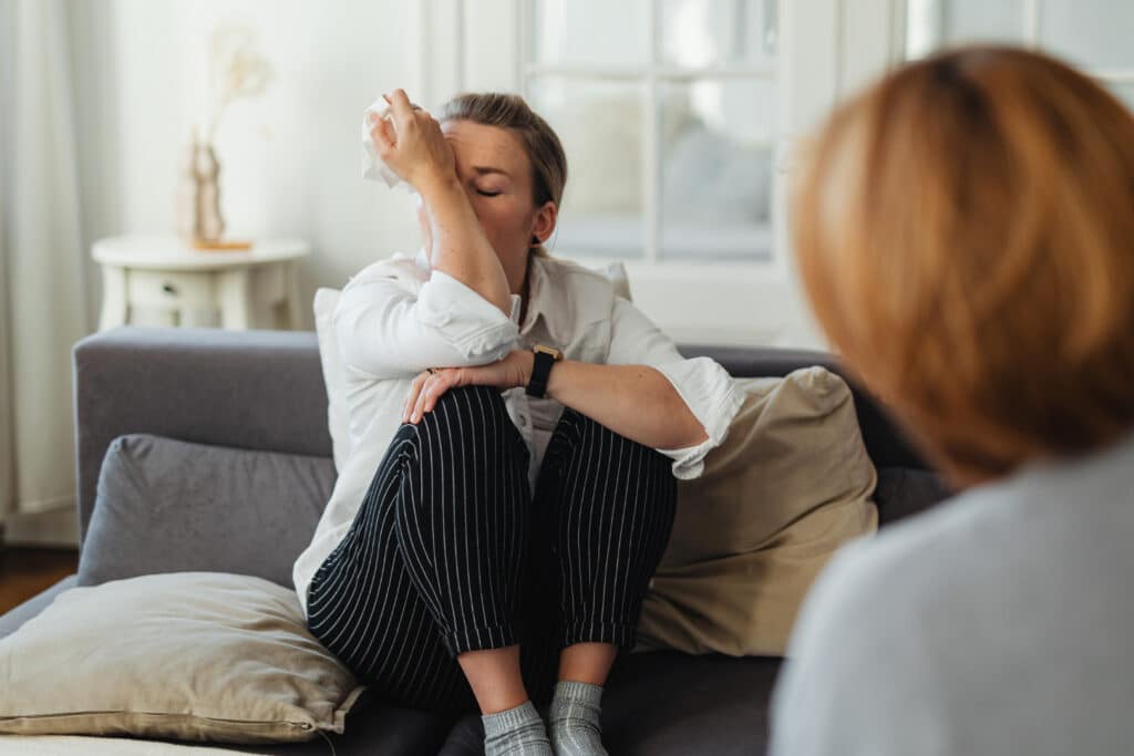 Seelsorgegespräch: Eine weinende Frau wird von einer zuhörenden Person begleitet